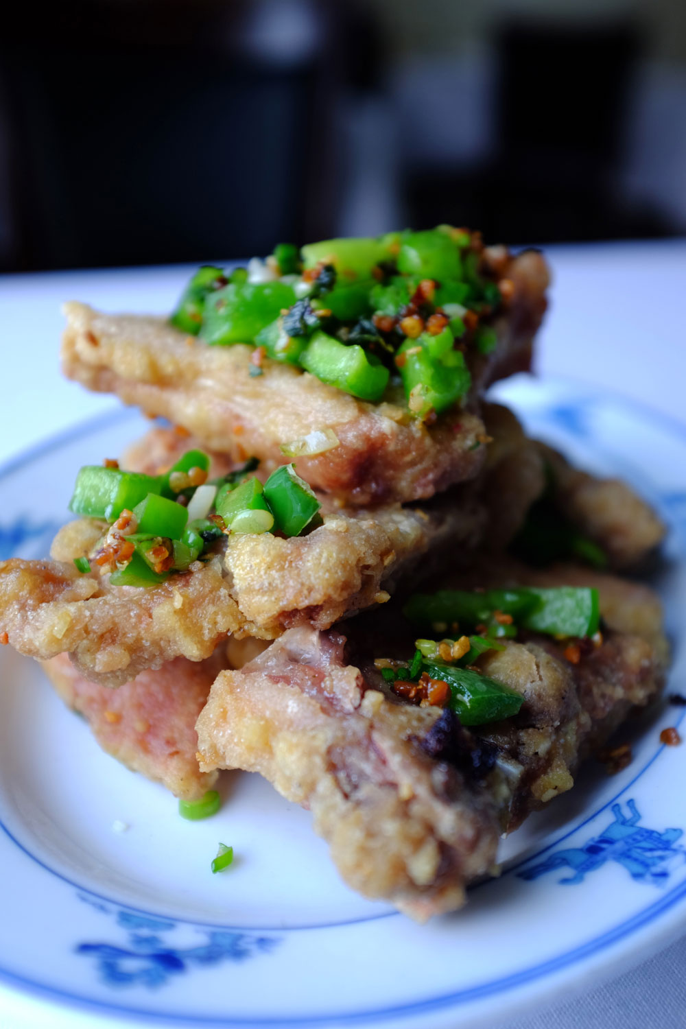 An image of stacked Salt and Peppered Porkchops on a blue and white dish.